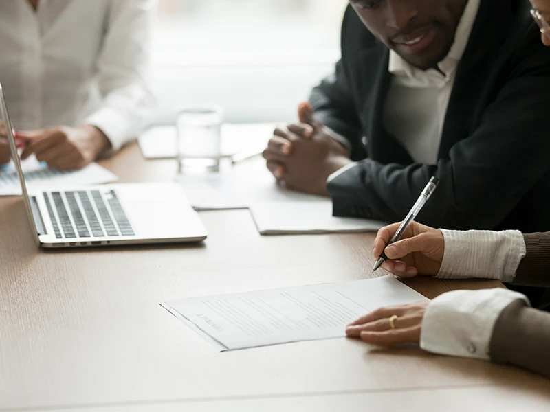 Ein verpflichtender Vertrag wird im Beisein eines Anwalts unterzeichnet.