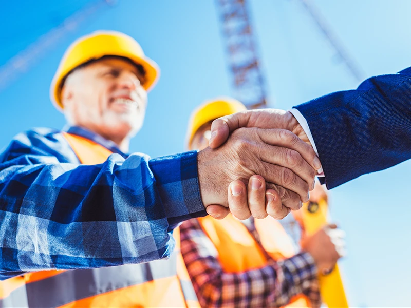 Handschlag zwischen Arbeiter und Besucher.