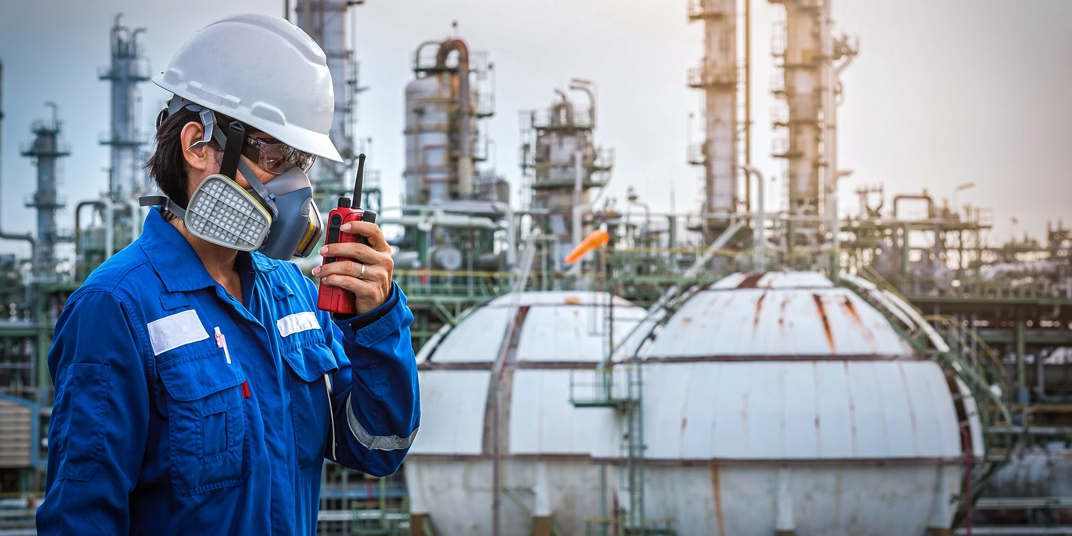 Eine Person in Schutzkleidung redet in ein Walkie-Talkie