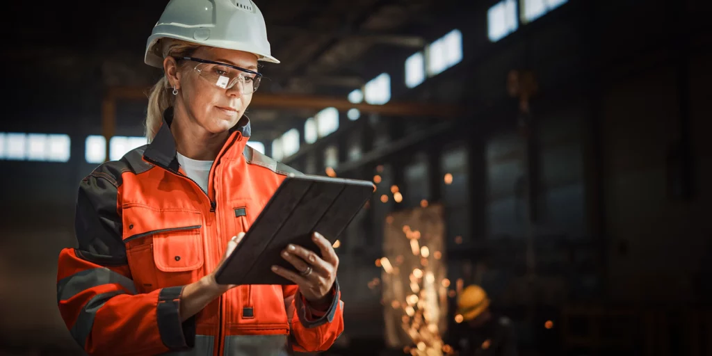 Eine Arbeiterin schaut auf ein Tablet