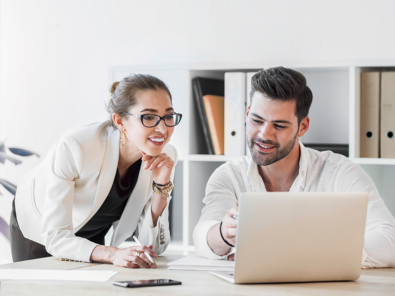 Zwei personen schauen gemainsam auf einen Laptop.