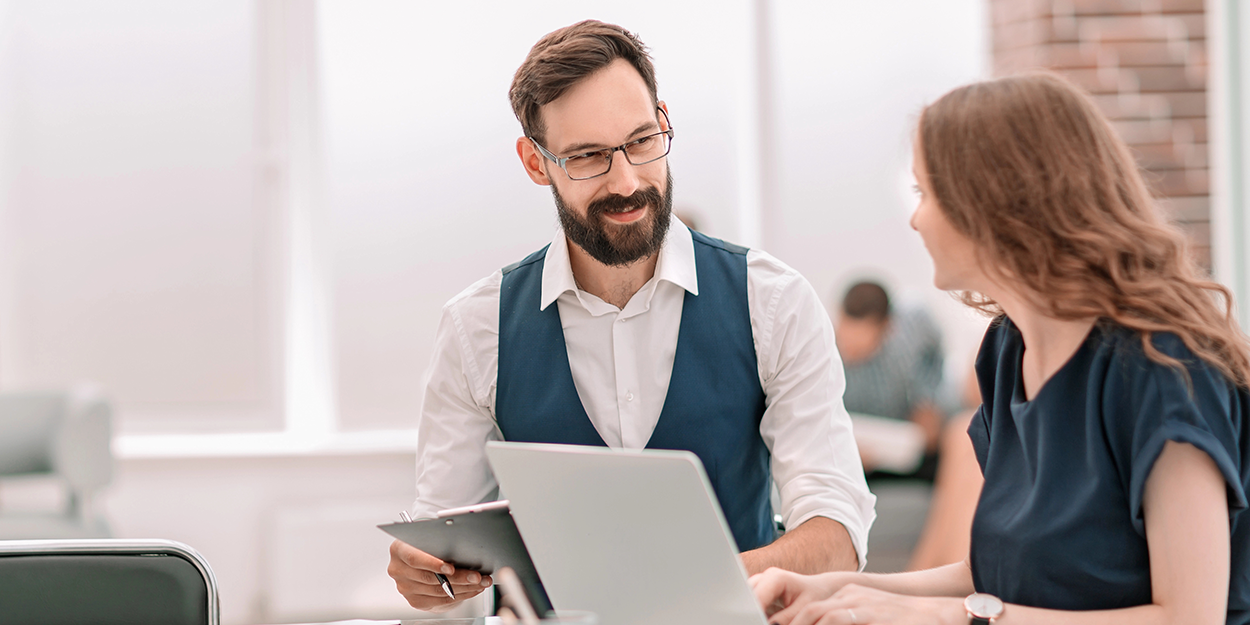 Ein Mann und eine Frau evaluieren gemeinsam die Leistungen der Mitarbeitenden