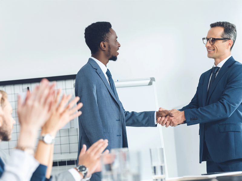 Zwei Personen geben sich die Hand.