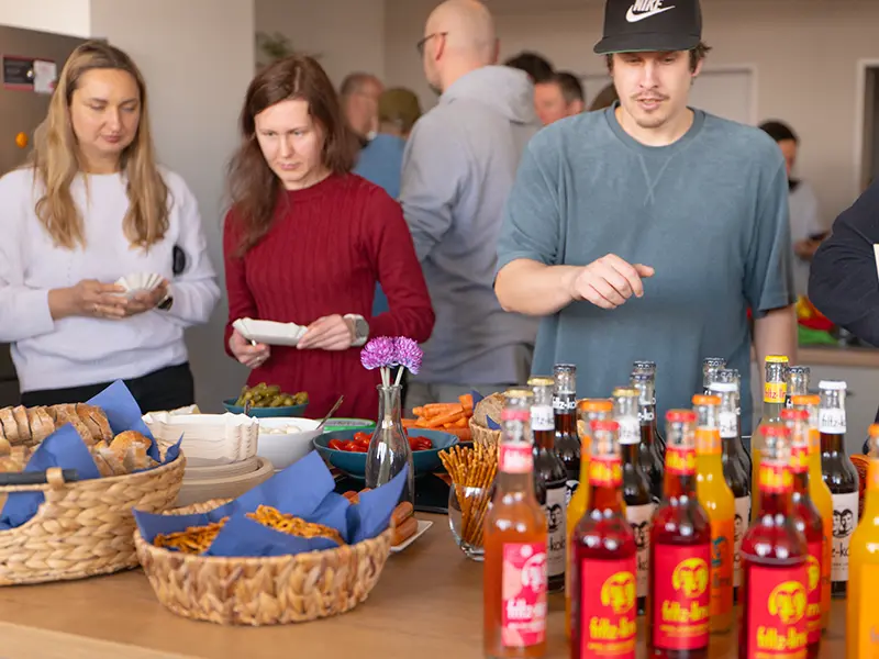 Company Kick Off bei domeba. Drei Personen stehen am Buffet.