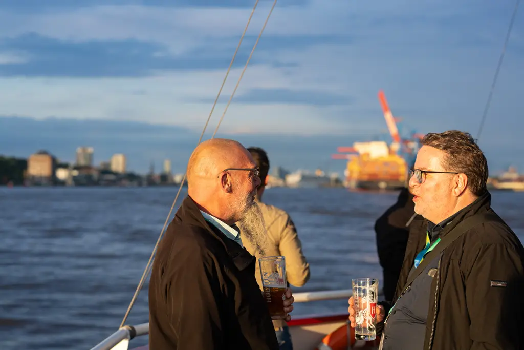 Zwei Personen unterhalten sich, im Hintergrund ist die Elbe zu sehen.