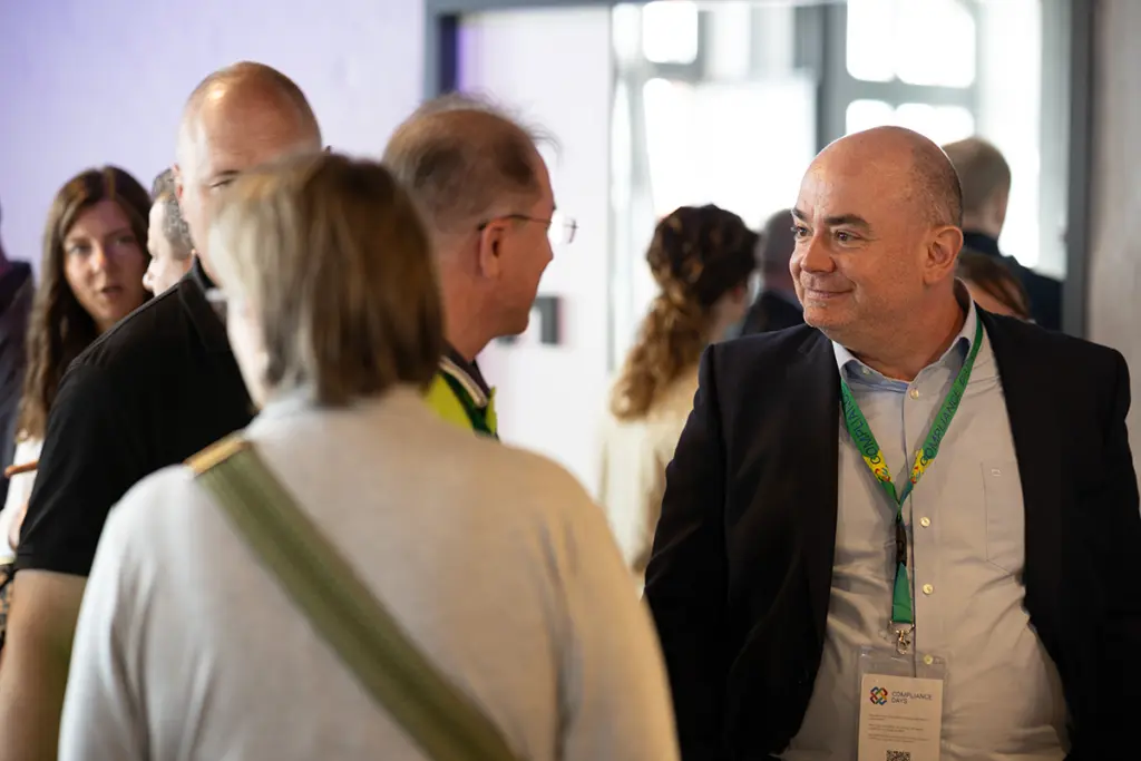 Matthias Domes sprich mit Personen auf den Compliance Days in Hamburg.