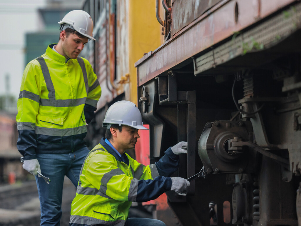 Zwei Mitarbeiter der Bahn prüfen die Sicherheit einer Bahn.